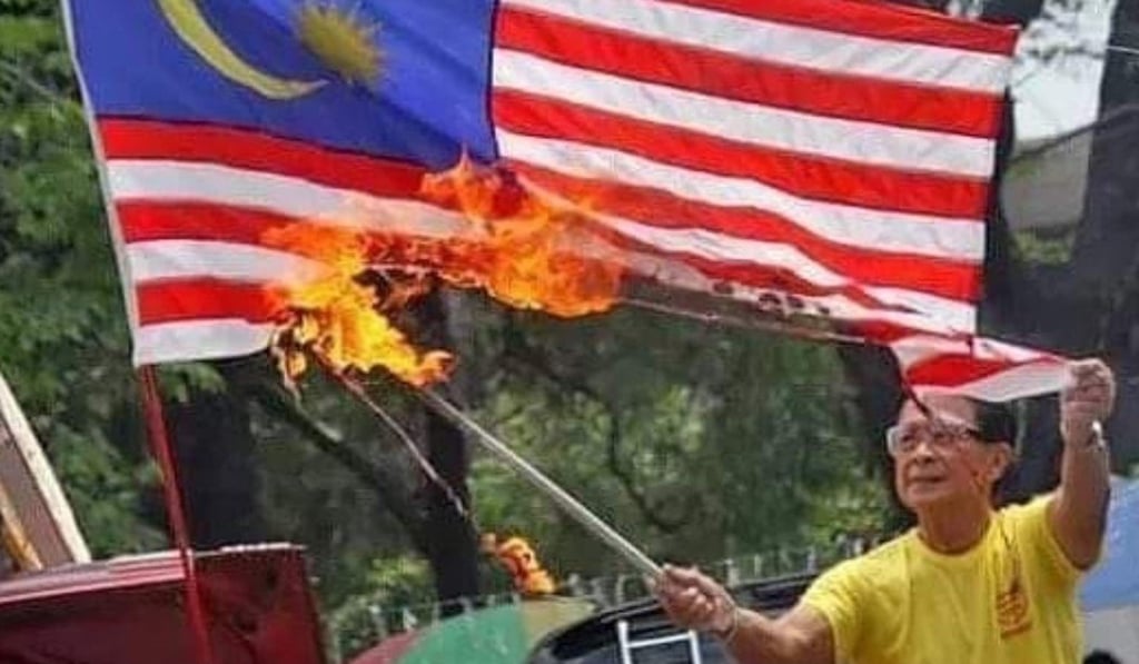 Screenshot of the Facebook post showing a man burning a Malaysian flag.