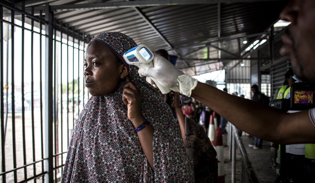 A woman gets her temperature measured at an Ebola screening station. Photo: AFP A woman gets her temperature measured at an Ebola screening station. Photo: AFP
