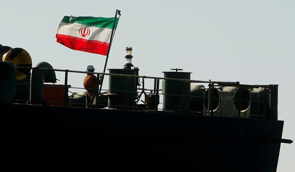 A crew member raises the Iranian flag on Adrian Darya 1. Photo: Reuters