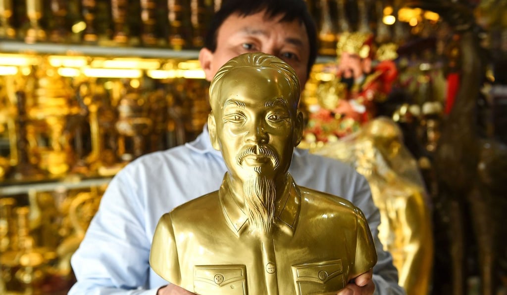 A shopkeeper posing with bust of Vietnam's revolutionary leader Ho Chi Minh. Photo: AFP