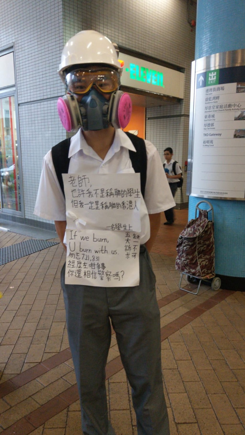 A student from Po Leung Kuk Ho Yuk Ching College in Tseung Kwan O stands outside Hang Hau MTR station displaying a paper that reads: “Teacher, I may not be well qualified for being a student, but I'm definitely well qualified for being a Hongkonger. After all that has happened, can you still believe in cops?” Photo: Susan Ramsay
