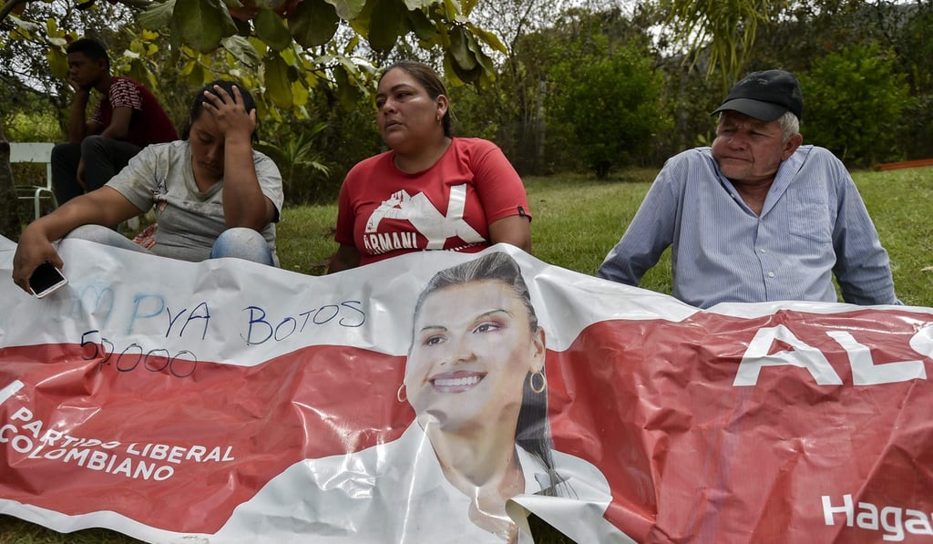 Relatives and friends of murdered mayoral candidate Karina Garcia mourns over one of her political banners in Suarez. Photo: AFP