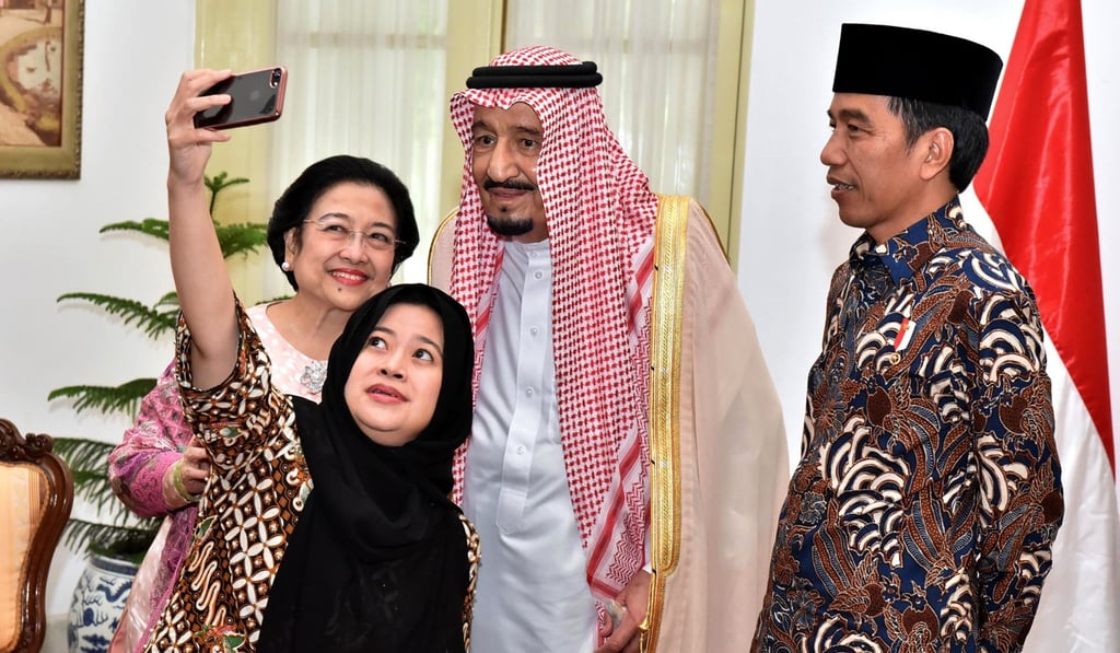Indonesian President Joko Widodo looks on as his coordinating Minister of Human Development and Cultural Affairs Puan Maharani and her mother, former president Megawati Sukarnoputri, and Saudi Arabia's King Salman take a selfie at the Presidential Palace in Jakarta. Photo: AFP