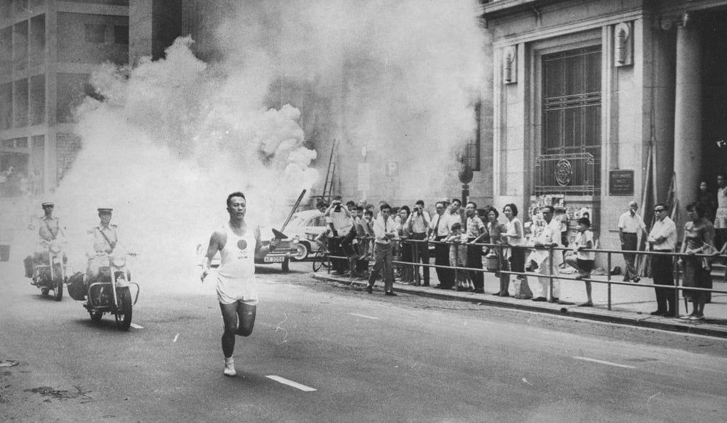 Swimmer Cheung Kin-man with the Olympic torch, in Queen’s Road Central, on September 4, 1964. Photo: SCMP Swimmer Cheung Kin-man with the Olympic torch, in Queen’s Road Central, on September 4, 1964. Photo: SCMP