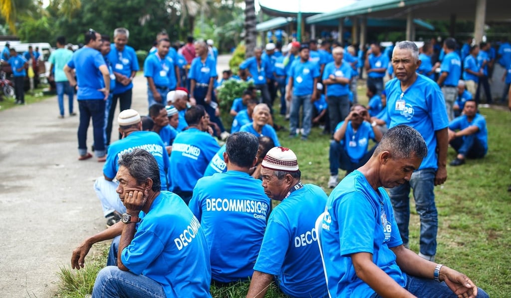 MILF rebels wait for transport to a weapons decommissioning ceremony. Photo: AFP