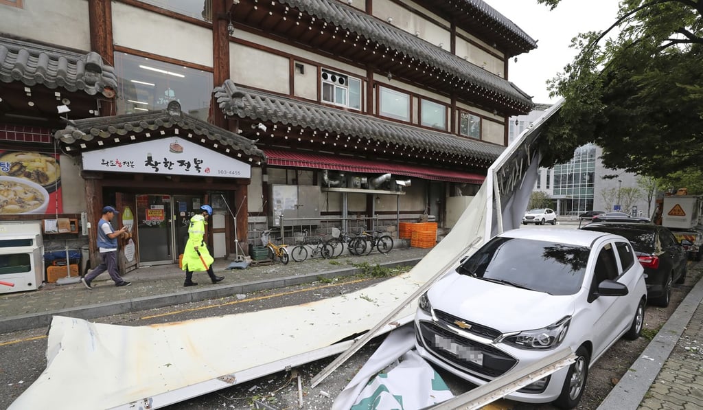 A vehicle is damaged by fallen signboard in Seoul. Photo: AP