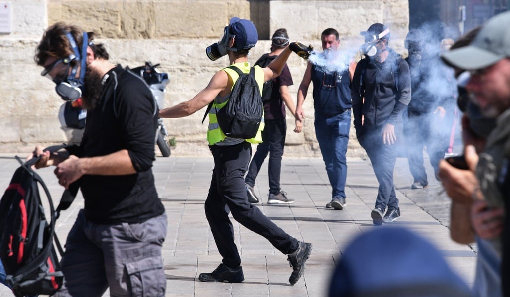 A protester throws back a tear gas canister during a yellow vest demonstration in Montpellier on Saturday. Photo: AFP