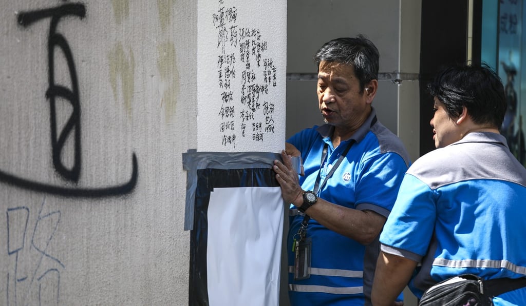 Workers cover up some of the damage done to the outside of an MTR station exit in Mong Kok. Photo: Tory Ho
