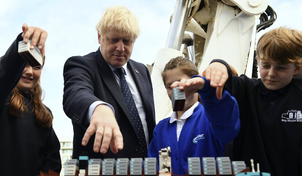 Britain's Prime Minister Boris Johnson takes part in an activity with schoolchildren as he visits the NLV Pharos, a lighthouse tender moored on the river Thames on Thursday. Photo: AP Britain's Prime Minister Boris Johnson takes part in an activity with schoolchildren as he visits the NLV Pharos, a lighthouse tender moored on the river Thames on Thursday. Photo: AP