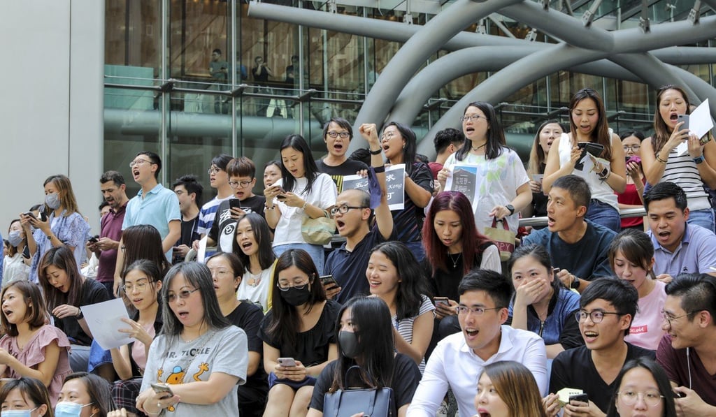Financial workers sing the protest anthem Glory to Hong Kong outside One Island East in Quarry Bay. Photo: May Tse