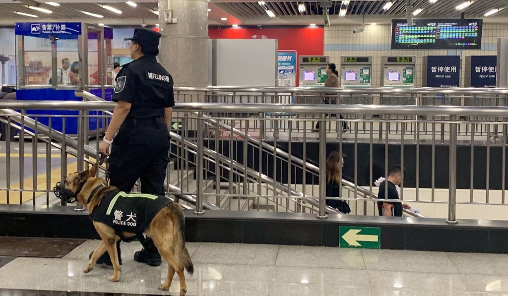 A police officer patrols with a dog at Wangfujing subway station on Wednesday. Photo: Kinling Lo