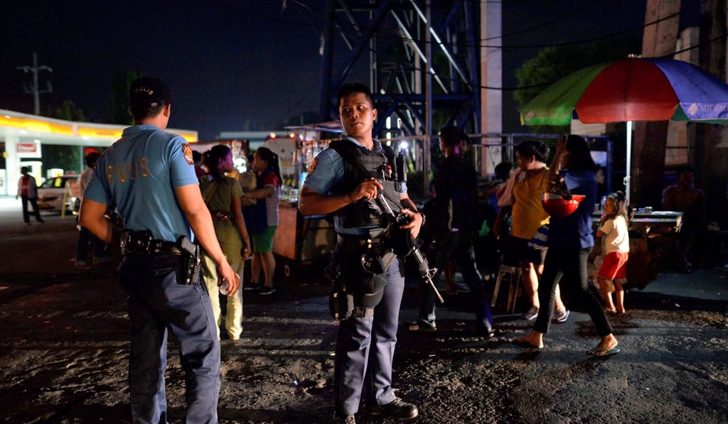 Police officers stand guard near A crime scene where a suspected drug addict was shot dead. Photo: Reuters