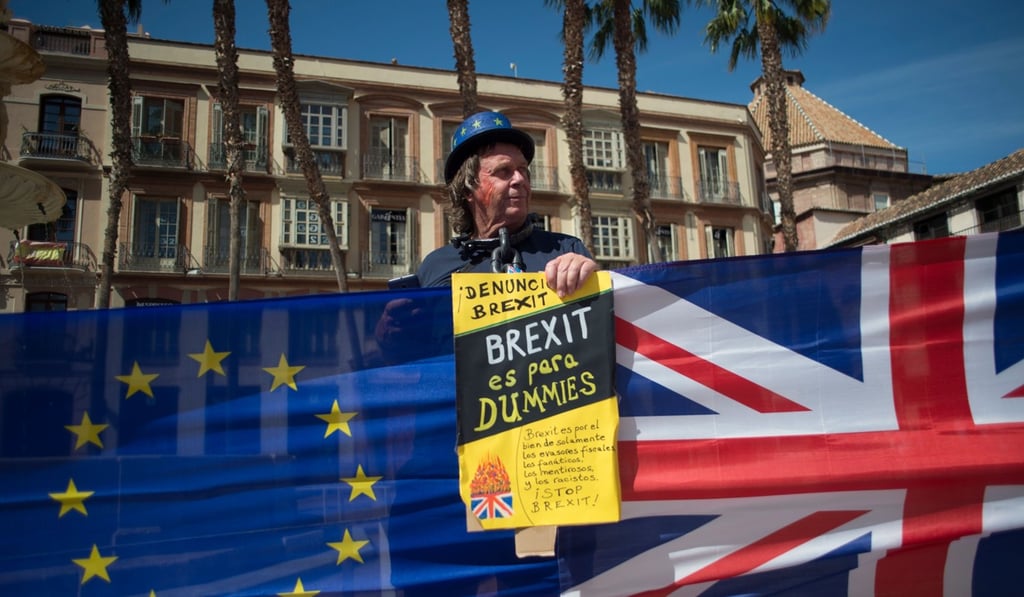 A man holds an European Union and British flags during a protest against Brexit in Malaga. Photo: AFP A man holds an European Union and British flags during a protest against Brexit in Malaga. Photo: AFP