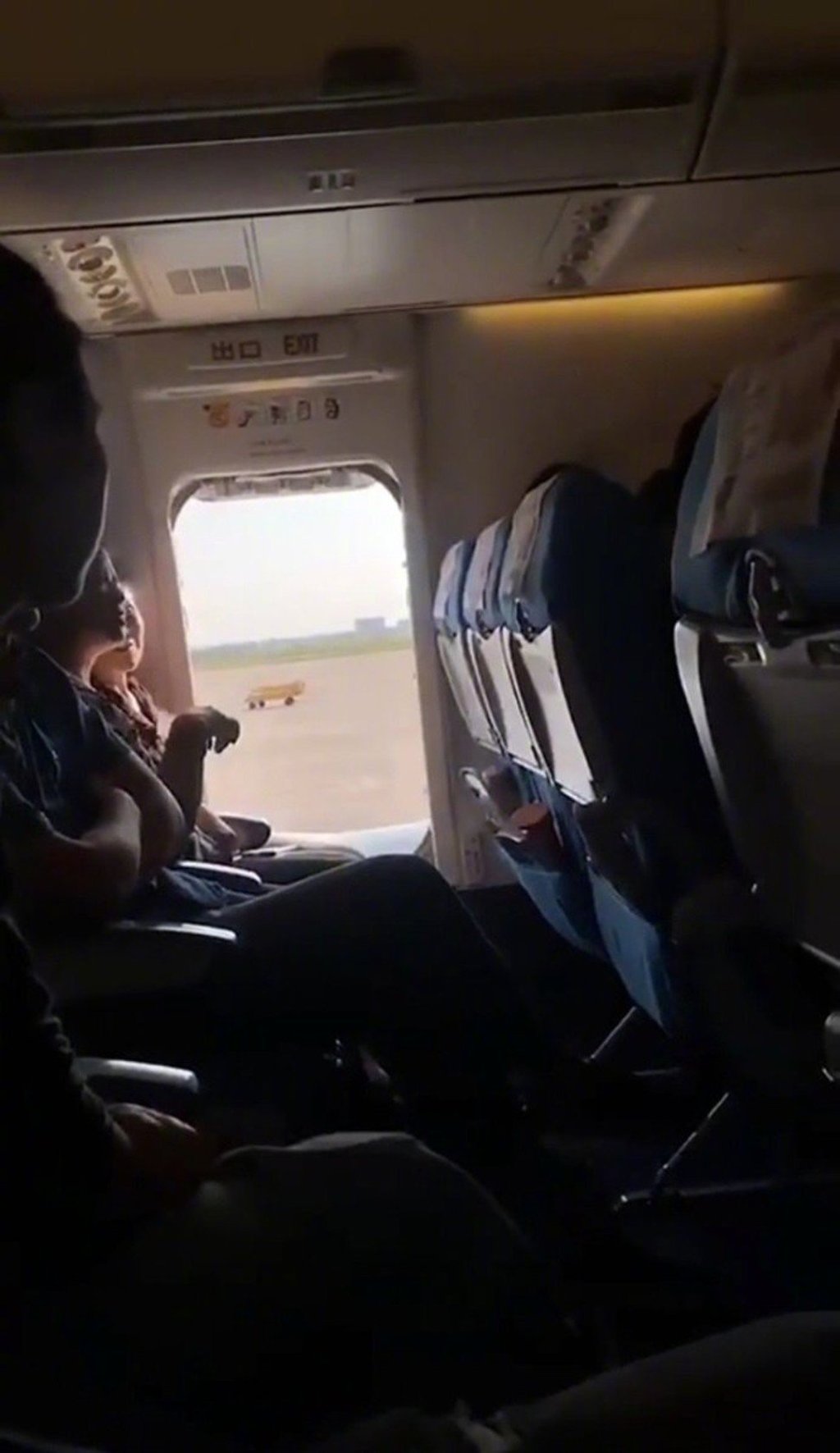 === PHOTO CAPTURED FROM WEIBO === A flight was delayed for an hour and a woman detained by police after she opened the emergency exit for Òa breath of fresh airÓ before the flight took off in central Hubei province on Monday. The incident happened on flight Xiamen Air MF8215, which was scheduled to take off in Wuhan at 15:45 after passengers boarded the plane for Lanzhou, Gansu province on the afternoon, reported the Btime Video. Air stewardess had briefed the woman, who looked to be in her 50s, about the rules of sitting next to the emergency exit and reminded her not to touch the button that could open the emergency exit. WEIBO