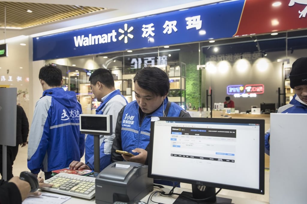 Delivery drivers wait for orders outside a Walmart store in Shanghai. Photo: Bloomberg