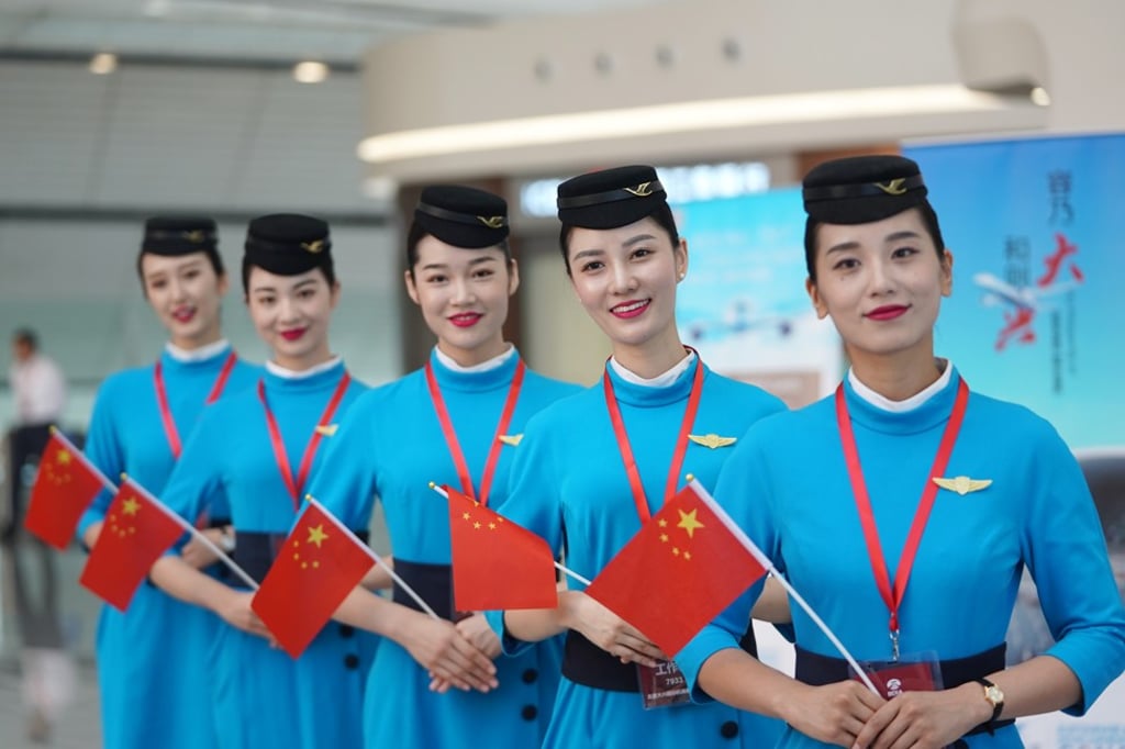 Staff members of Xiamen Airlines greet passengers at the terminal of Daxing International Airport in Beijing, China. Photo: Ju Huanzong/Xinhua