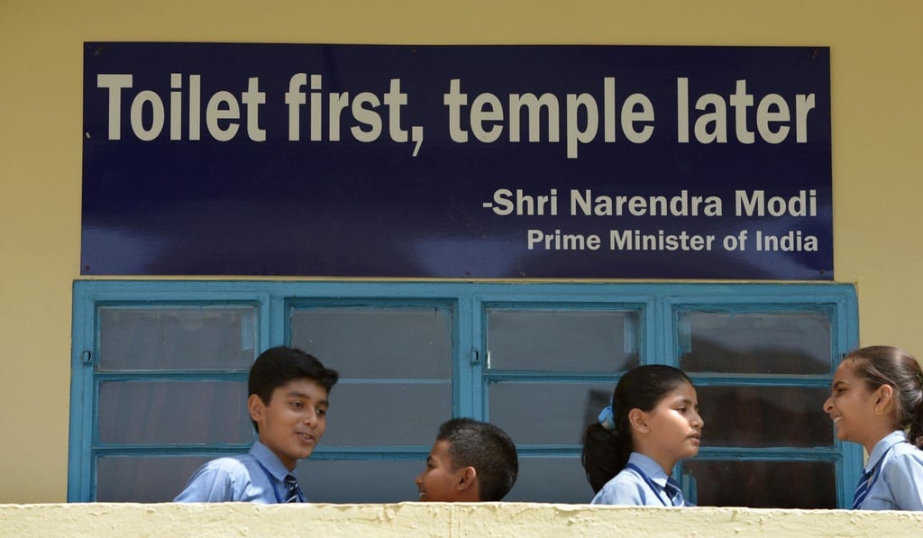 Indian schoolchildren talk in front of a poster bearing a quote from Prime Minister Narendra Modi at a school in New Delhi in September 2014. Photo: AFP