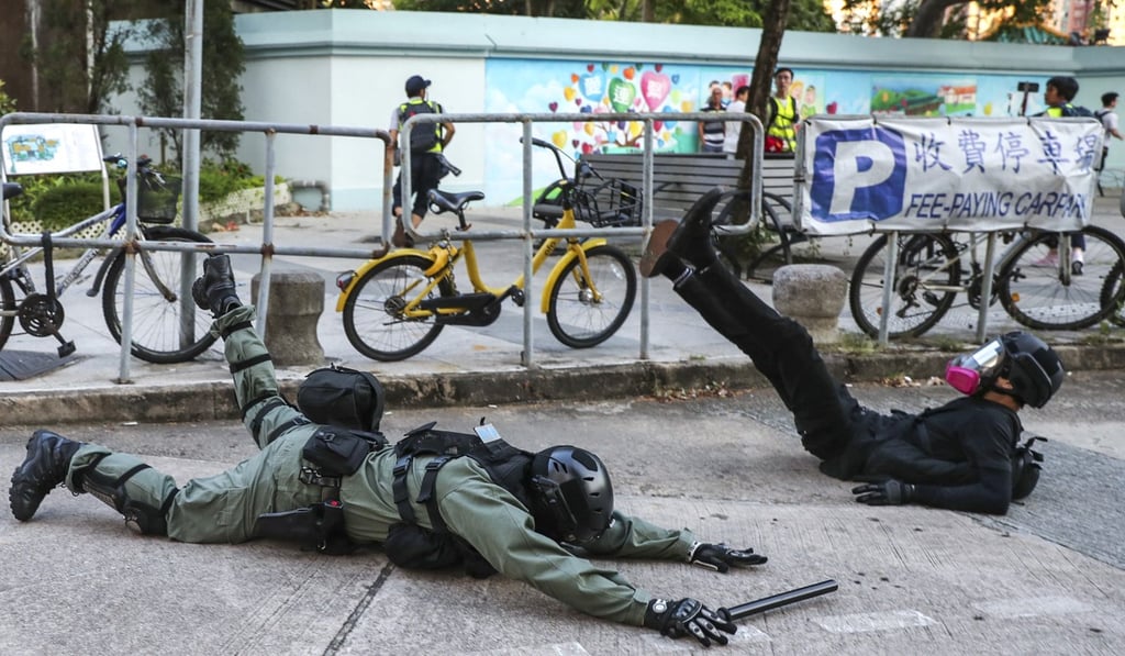 A riot police officer falls to the ground while trying to catch an anti-government protester in Sha Tin. Photo: Sam Tsang