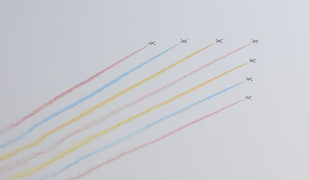 One young spectator was delighted by a formation of jets trailing colourful smoke. Photo: Simon Song