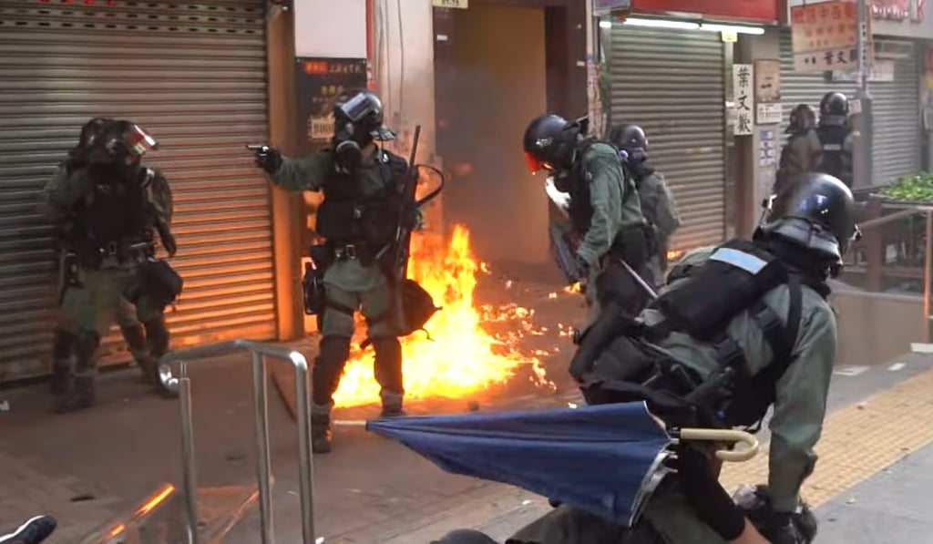 A police officers points his gun at protesters in Tai Ho Street, Tsuen Wan on Tuesday. Photo: Campus TV, HKUSU A police officers points his gun at protesters in Tai Ho Street, Tsuen Wan on Tuesday. Photo: Campus TV, HKUSU