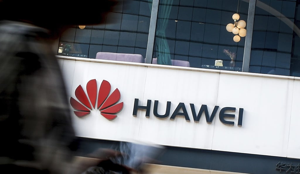 A woman walks by a Huawei retail store in Beijing. Photo: AP