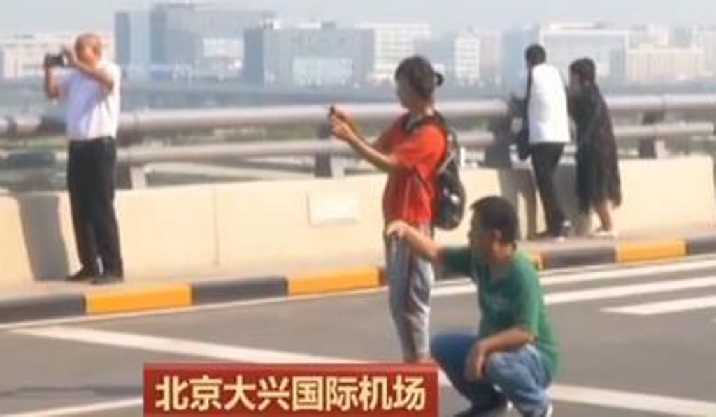 Security staff at Beijing Daxing International Airport are warning camera-happy visitors they could pose a danger to themselves, road users and travellers. Photo: CCTV Security staff at Beijing Daxing International Airport are warning camera-happy visitors they could pose a danger to themselves, road users and travellers. Photo: CCTV