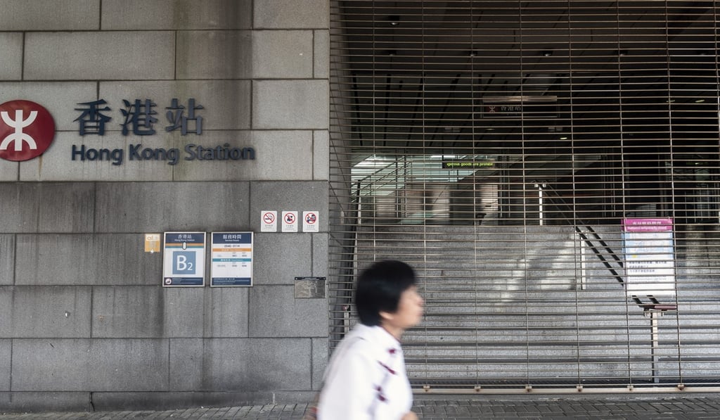 A pedestrian walks past a closed entrance to Hong Kong station on Saturday. Photo: Bloomberg A pedestrian walks past a closed entrance to Hong Kong station on Saturday. Photo: Bloomberg