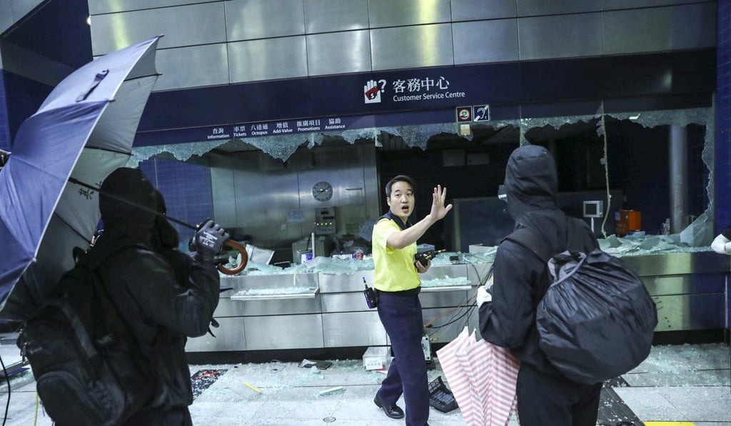 An MTR employee tries to stop protesters causing further damage at Tai Wai MTR station. Photo: Sam Tsang An MTR employee tries to stop protesters causing further damage at Tai Wai MTR station. Photo: Sam Tsang
