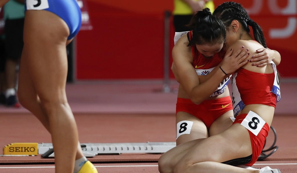 Ge Manqi (right) of China is comforted by her teammate Liang Xiaojing after the women's 4x100m relay final in Doha. Photo: Xinhua