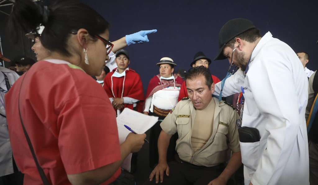 Doctors check the vitals of Colonel Cristian Rueda Ramos, one of several police officers who was detained. Photo: AP