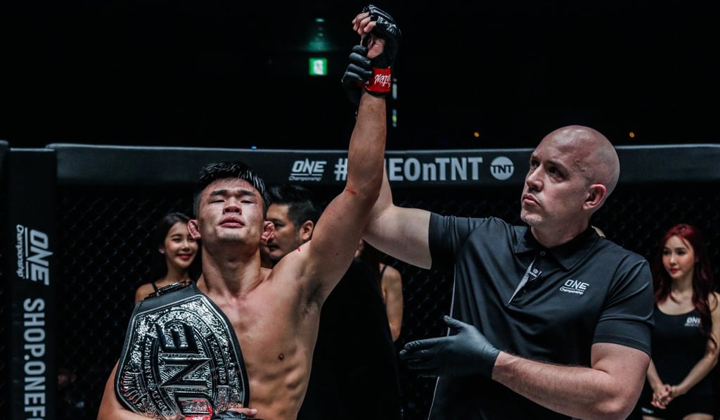 Referee Olivier Coste raises Christian Lee’s arm.
