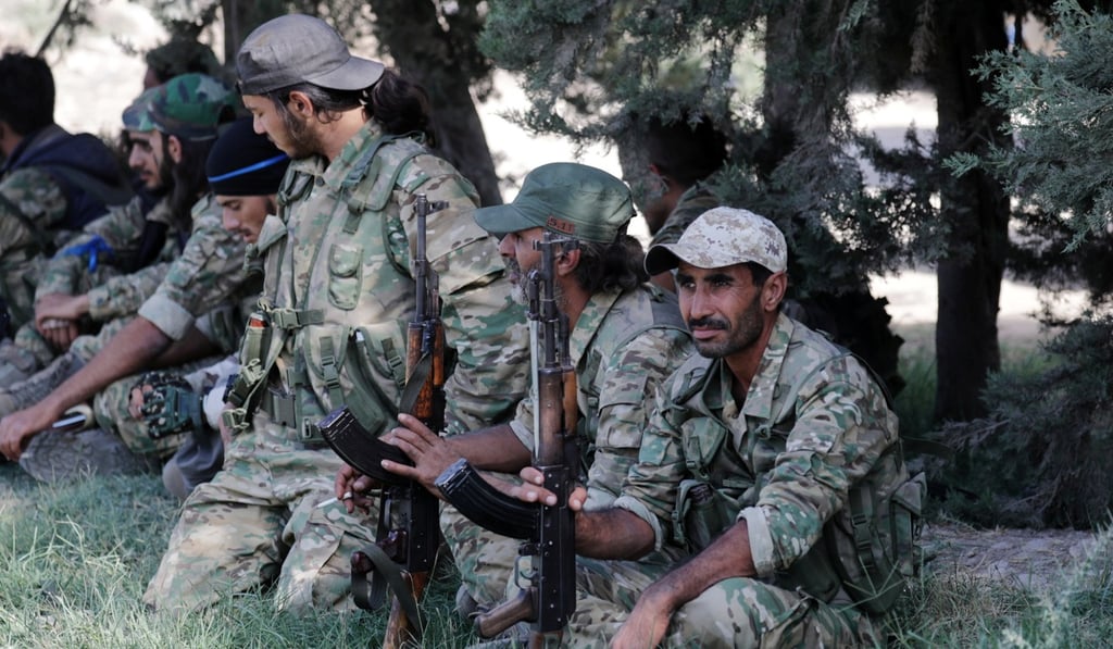 Turkey-backed Syrian rebel fighters sit together near the border town of Tel Abyad, Syria. Photo: Reuters Turkey-backed Syrian rebel fighters sit together near the border town of Tel Abyad, Syria. Photo: Reuters