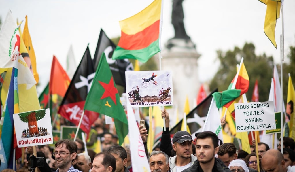 People hold pro-Kurd flags and banner in Paris. Photo: AFP