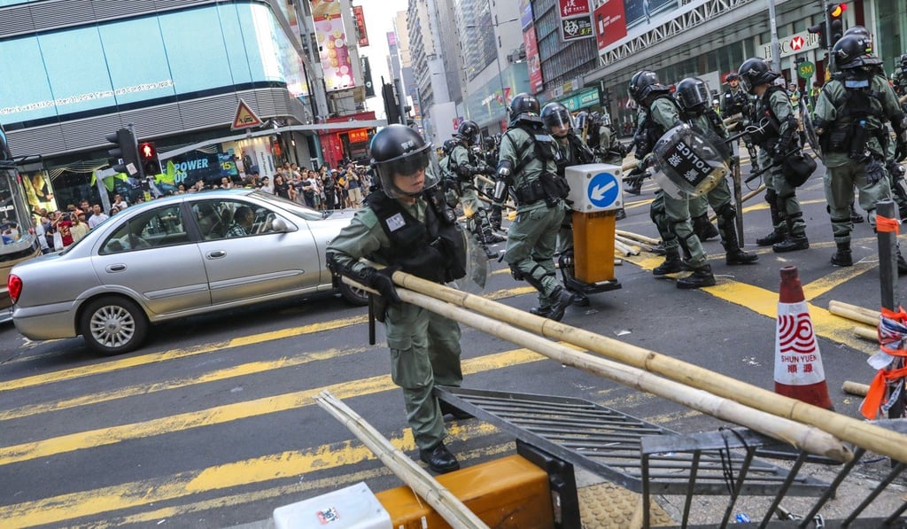 Riot police clear blockades from a road in Mong Kok on Sunday. Photo: May Tse