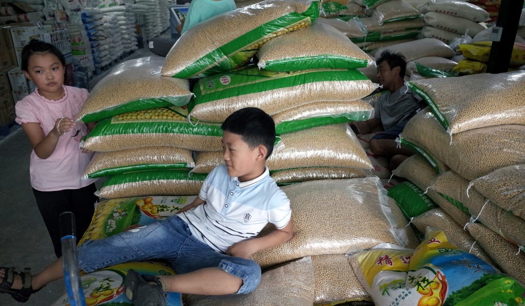 Chinese children play around bags of soybeans at a grain wholesale market in Beijing in August. Photo: EPA-EFE