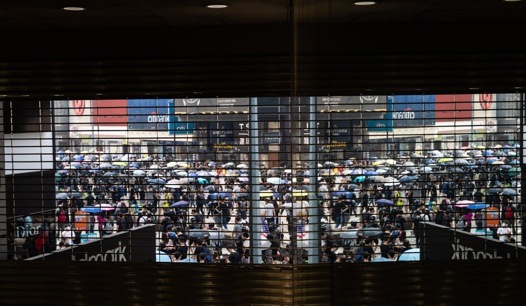 Demonstrators march outside the closed Goldmark mall in the prime shopping district of Causeway Bay. Photo: Bloomberg Demonstrators march outside the closed Goldmark mall in the prime shopping district of Causeway Bay. Photo: Bloomberg