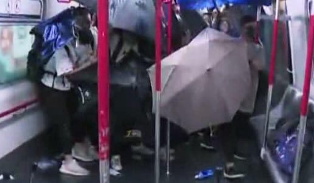 Passengers opened their umbrellas to protect themselves in the train at Prince Edward MTR Station after police officers stormed into a train in August. Photo: Handout