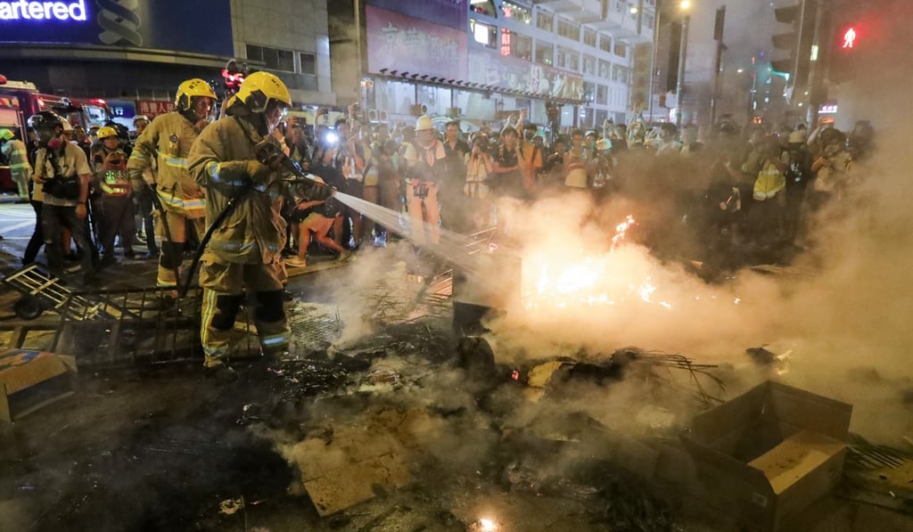 Firefighters put out a fire set by protesters on Nathan Road on September 22. Photo: Edmond So