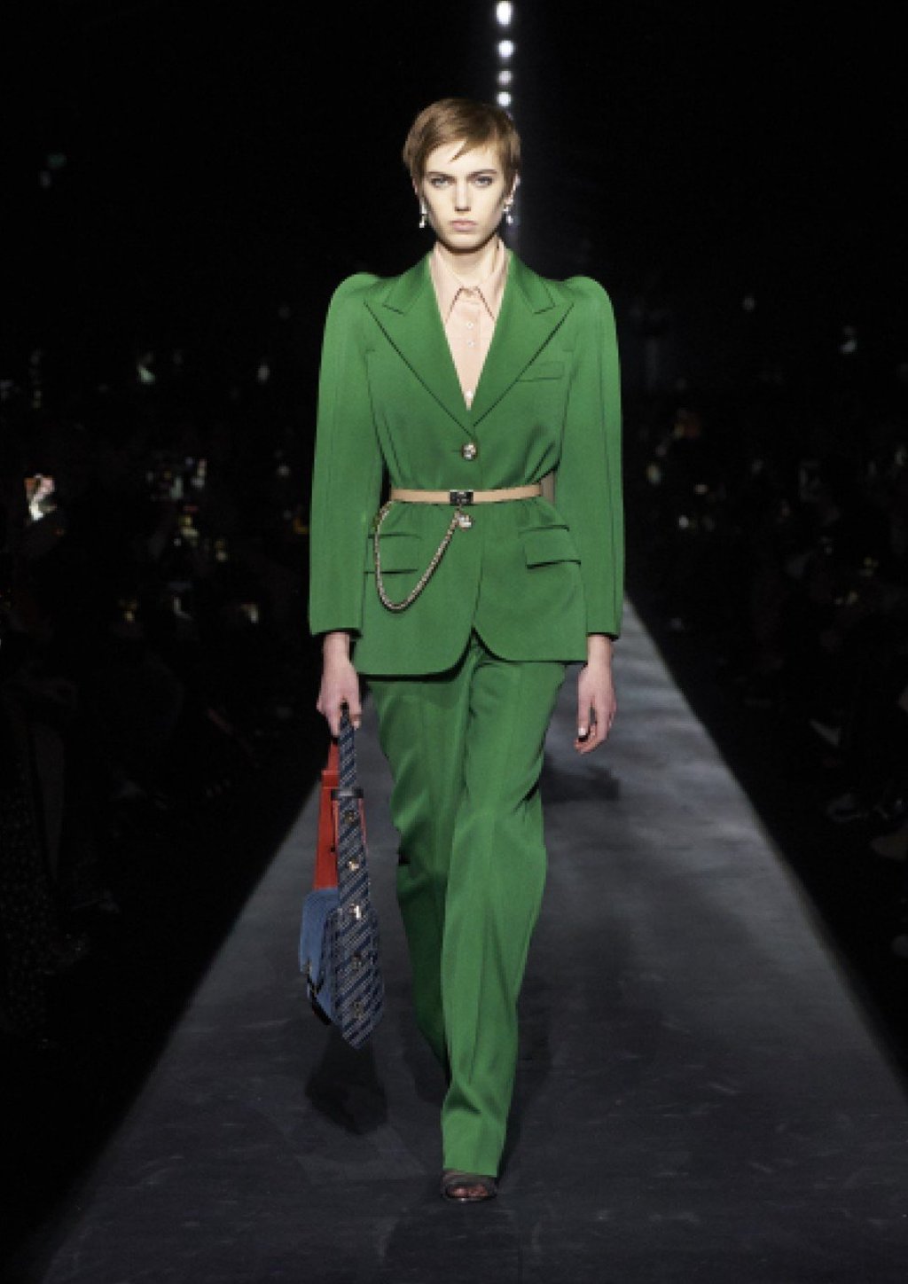 Givenchy featured a classic emerald pantsuit with exaggerated curving shoulders. Givenchy featured a classic emerald pantsuit with exaggerated curving shoulders.