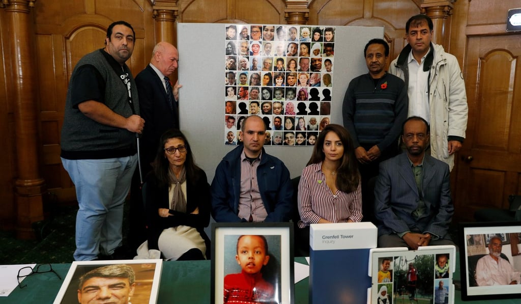 Relatives of victims of the Grenfell Tower fire pose with pictures during a news conference in London on Wednesday. Photo: Reuters