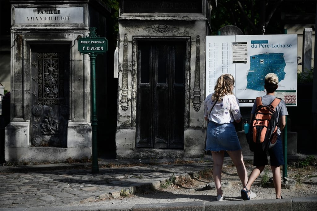 Tourists look at the map of the Père Lachaise Cemetery, in Paris. Photo: AFP Tourists look at the map of the Père Lachaise Cemetery, in Paris. Photo: AFP