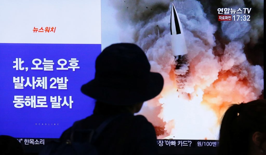 People watch a TV broadcast about the missile launch. Photo: Reuters