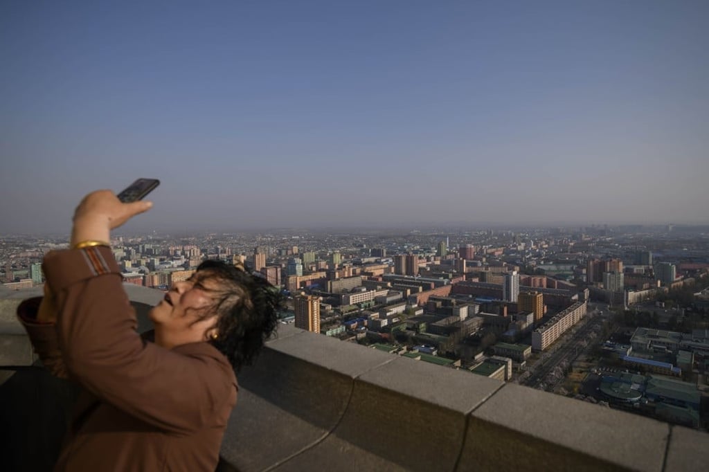A Chinese tourist takes a selfie on a viewing deck of Pyongyang’s Juche Tower. Photo: AFP