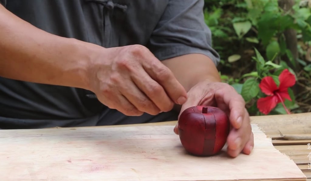 “Grandpa Amu” puts the finishing touches to an interlocking puzzle known as a Lu Ban lock. Photo: Handout