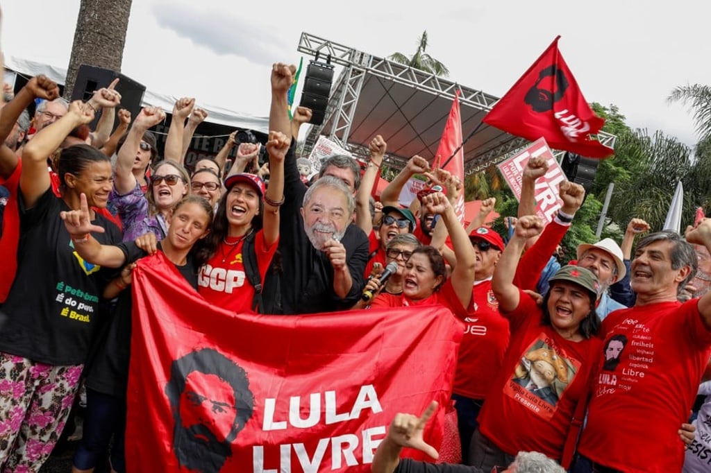 Supporters of Brazil’s former President Luiz Inacio Lula da Silva cheer outside the Federal Police headquarters. Photo: Reuters Supporters of Brazil’s former President Luiz Inacio Lula da Silva cheer outside the Federal Police headquarters. Photo: Reuters
