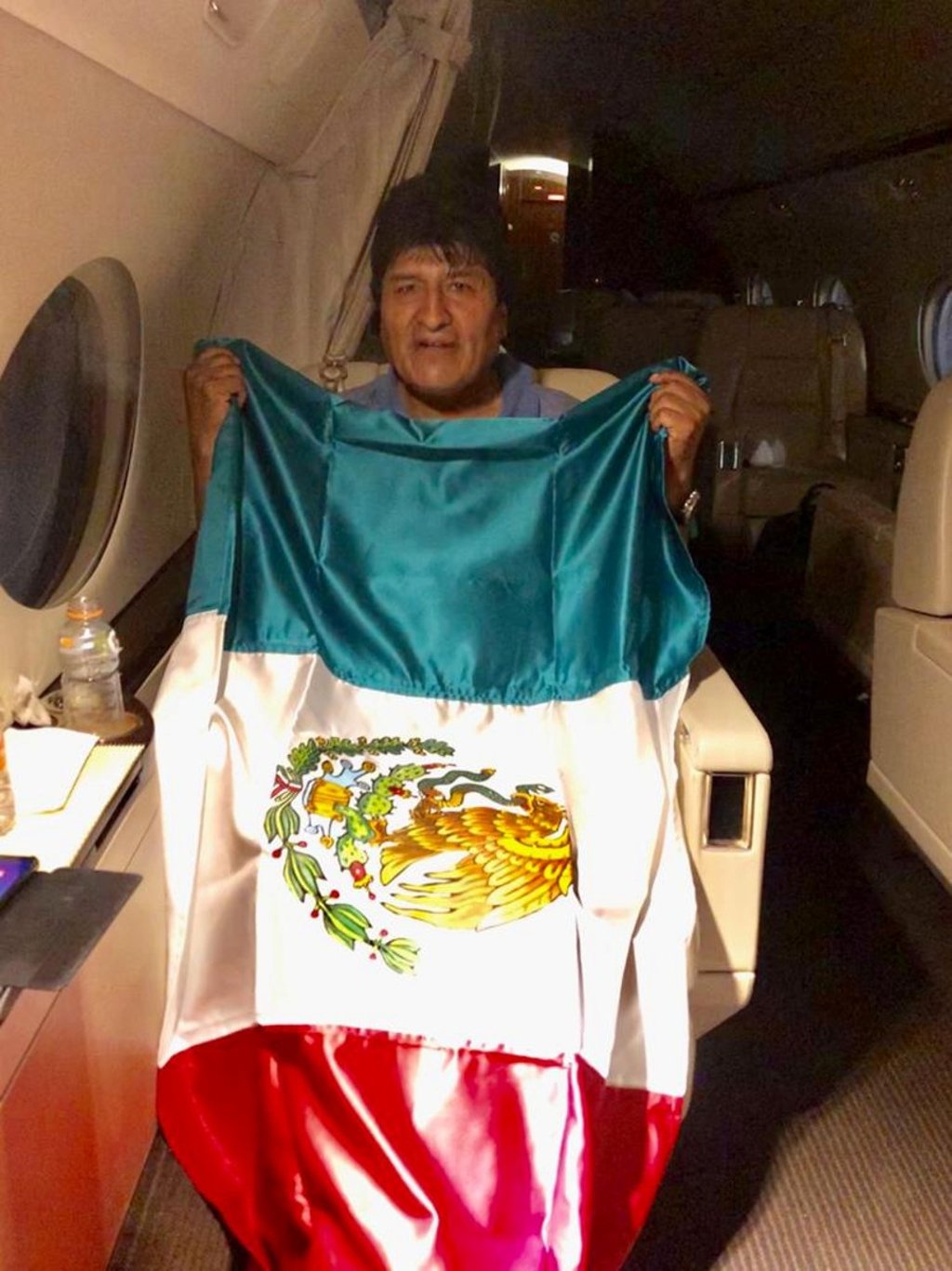 Former Bolivian President Evo Morales holds a Mexican flag on board a Mexican government aircraft. Photo: Twitter