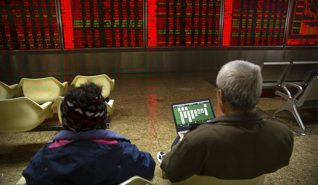 A Chinese investor uses a laptop as he monitors stock prices at a brokerage house in Beijing on November 4. Photo: AP