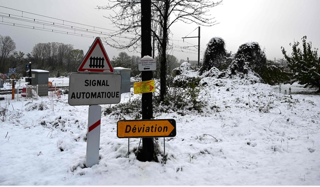 Road signs by a railway crossing covered with snow near Tournon-sur-Rhone. Photo: AFP