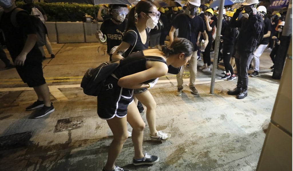A girl is sick after riot police use tear gas against protesters in Sheung Wan, Hong Kong. Photo: James Wendlinger