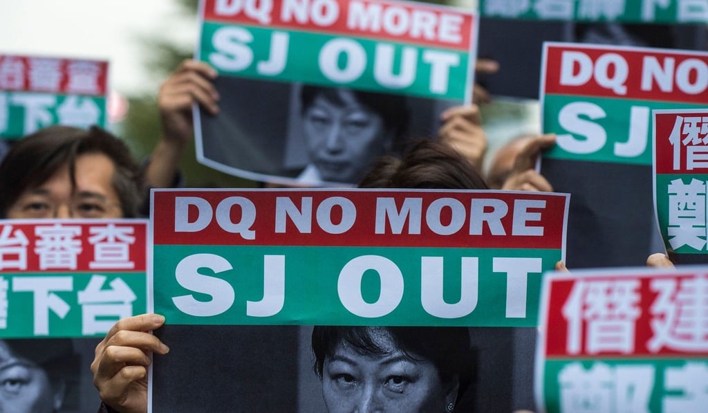People hold posters of Secretary for Justice Teresa Cheng at a protest outside the Hong Kong government’s headquarters in Tamar, Admiralty, on January 28, 2018. The rally was organised after pro-democracy activist Agnes Chow was barred from contesting the Legislative Council election. Photo: AFP